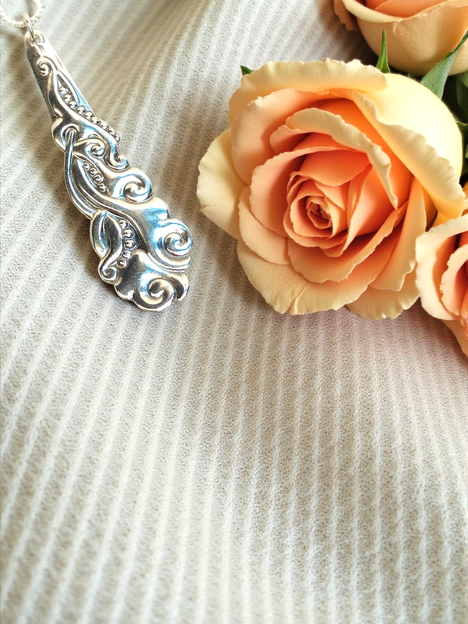 a vintage silver spoon necklace and a rose