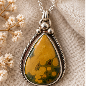 Ocean Jasper sterling silver teardrop pendant styled with linen and dried botanicals